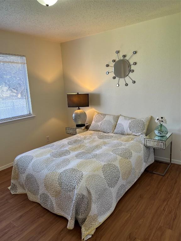 bedroom featuring hardwood / wood-style floors and a textured ceiling