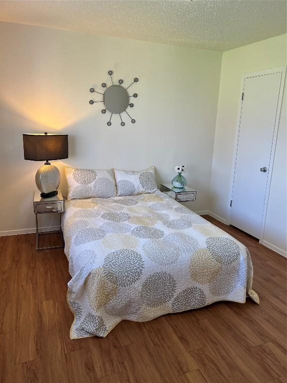 bedroom featuring wood-type flooring and a textured ceiling