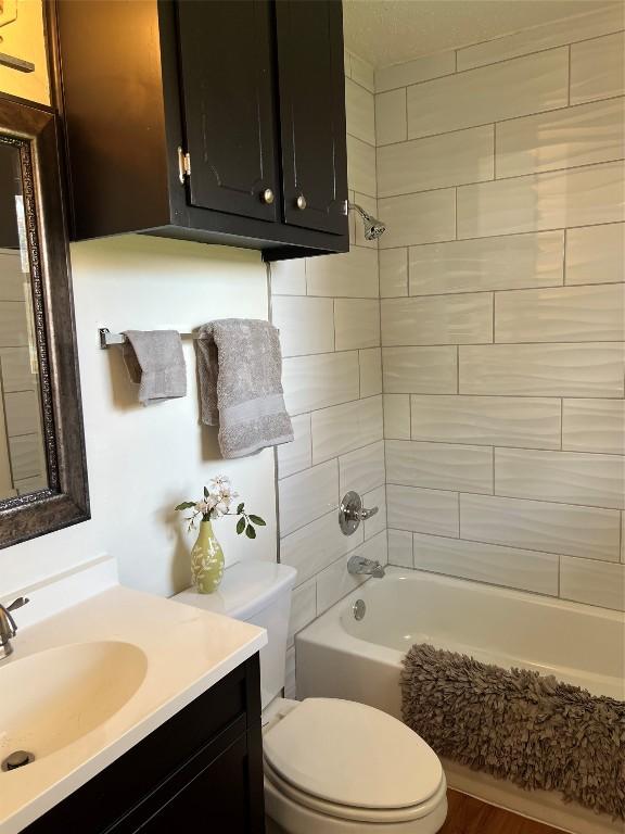 full bathroom featuring vanity, toilet, and tiled shower / bath combo