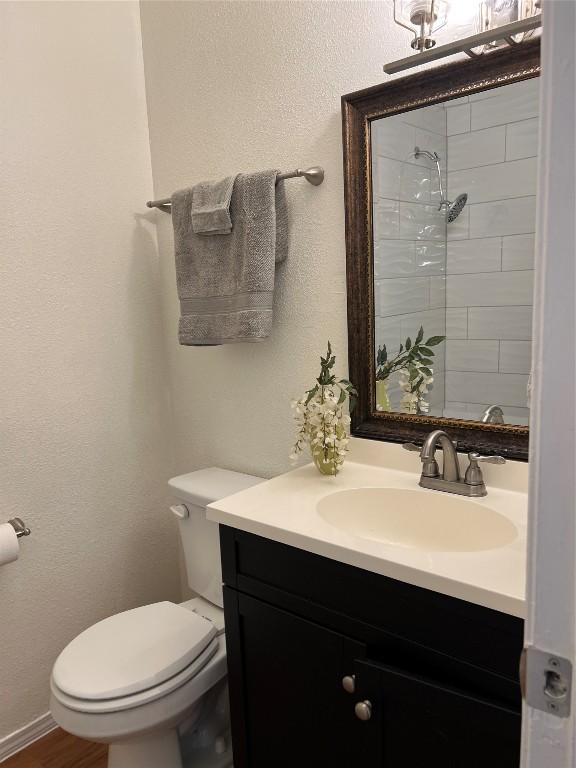 bathroom with vanity, toilet, and wood-type flooring