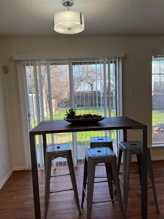 dining area featuring plenty of natural light, hardwood / wood-style floors, and a textured ceiling