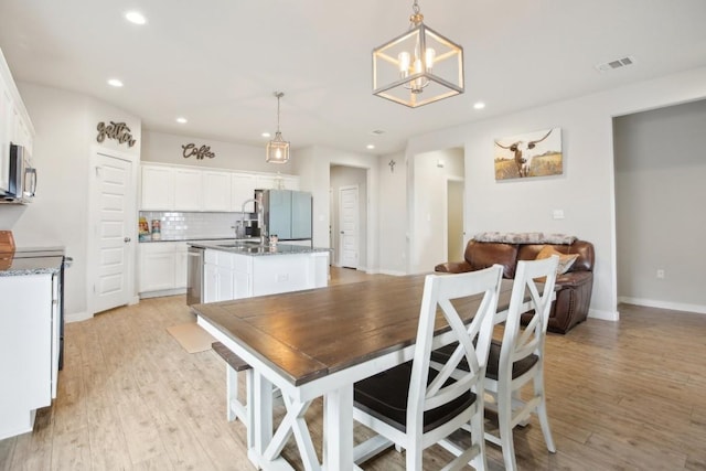 dining room with a chandelier and light hardwood / wood-style floors