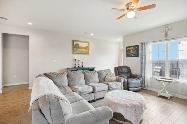 living room featuring light hardwood / wood-style flooring and ceiling fan