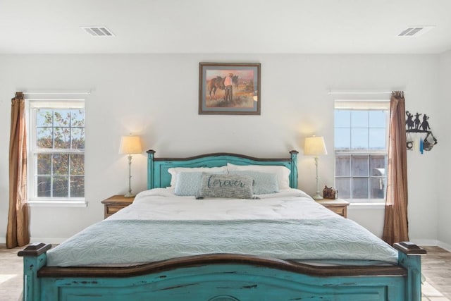 bedroom featuring light hardwood / wood-style floors and multiple windows