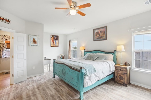 bedroom featuring multiple windows, ceiling fan, and light hardwood / wood-style floors