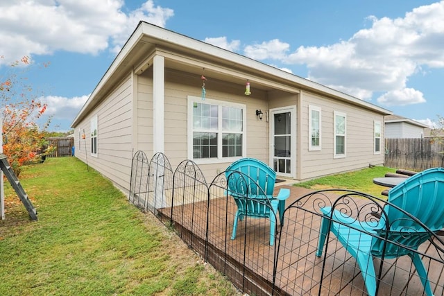 rear view of house featuring a lawn and a patio