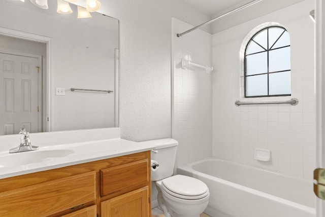 full bathroom with vanity, tiled shower / bath combo, and toilet