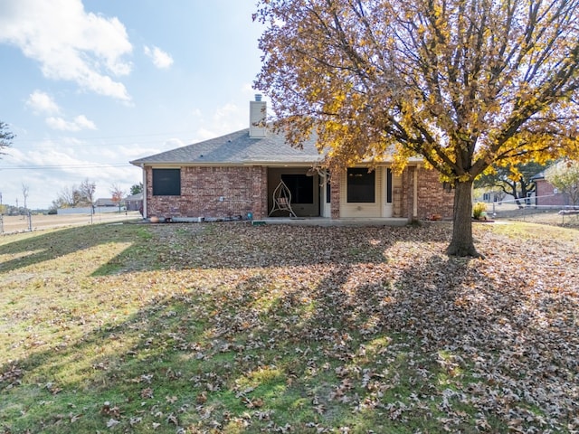 back of house with a yard and a patio