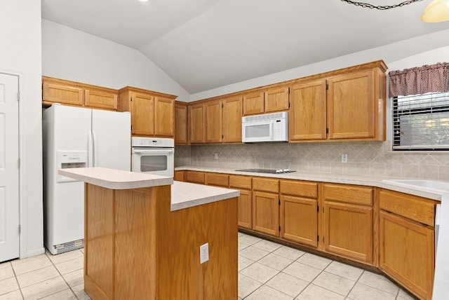 kitchen featuring tasteful backsplash, white appliances, vaulted ceiling, light tile patterned floors, and a center island