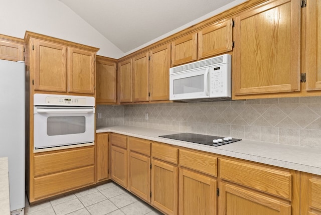 kitchen featuring light tile patterned floors, white appliances, tasteful backsplash, and vaulted ceiling