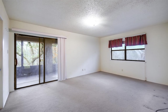 carpeted spare room featuring a textured ceiling