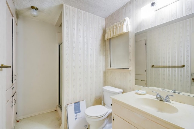 bathroom featuring vanity, toilet, a shower with shower door, and a textured ceiling