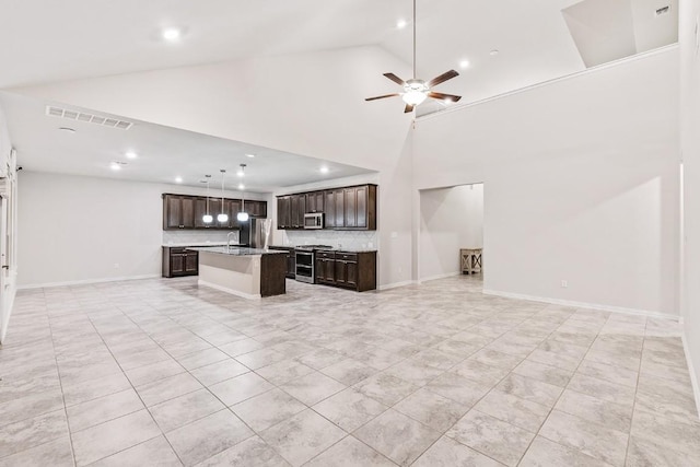 unfurnished living room featuring ceiling fan, sink, and high vaulted ceiling