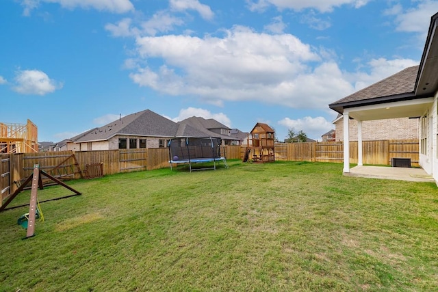 view of yard featuring a trampoline, a patio, and a playground