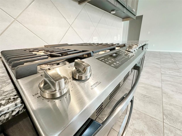 room details with tasteful backsplash, green cabinets, and gas stove