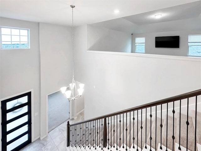 stairs featuring an inviting chandelier