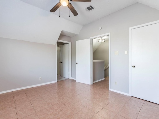 interior space featuring ceiling fan, a walk in closet, and vaulted ceiling