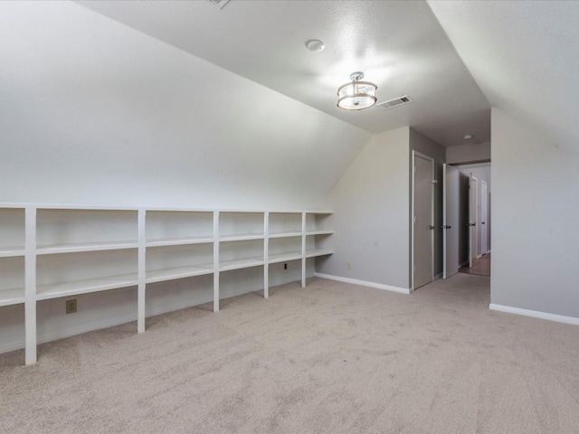 additional living space with light colored carpet and vaulted ceiling