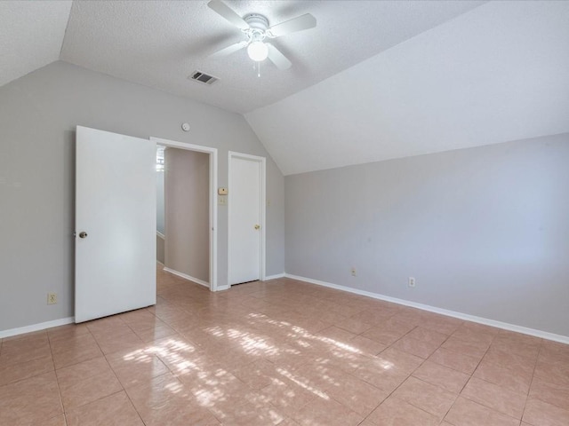 bonus room with a textured ceiling, ceiling fan, light tile patterned floors, and lofted ceiling