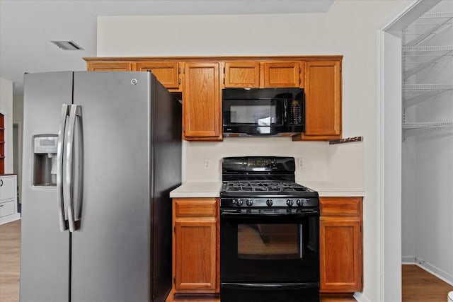 kitchen with black appliances and wood-type flooring