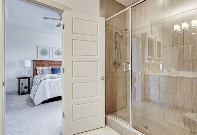 bathroom featuring a shower with door and ceiling fan