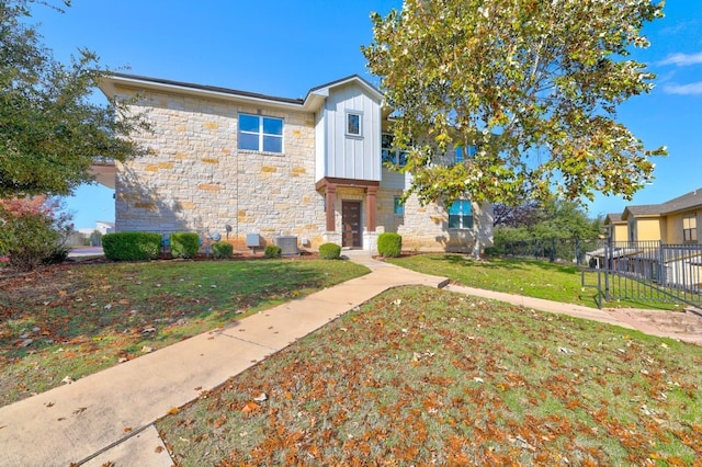 view of front of house featuring central AC unit and a front lawn