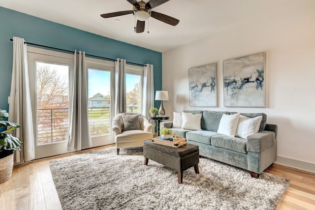 living room featuring light wood-type flooring and ceiling fan