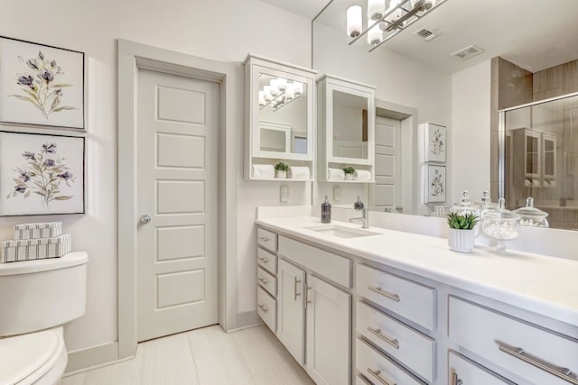 bathroom featuring tile patterned floors, a shower with door, vanity, and toilet