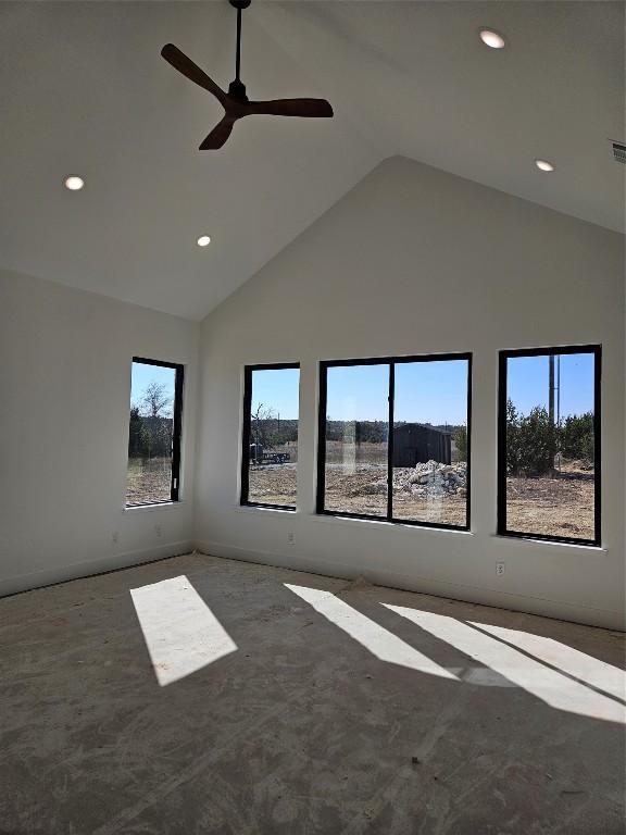 empty room with ceiling fan and high vaulted ceiling