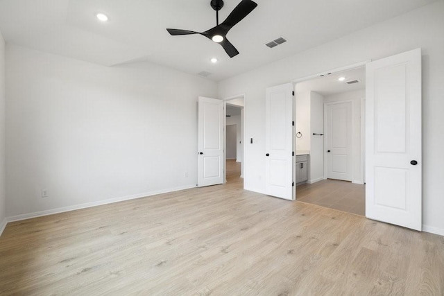 unfurnished bedroom with connected bathroom, ceiling fan, and light wood-type flooring