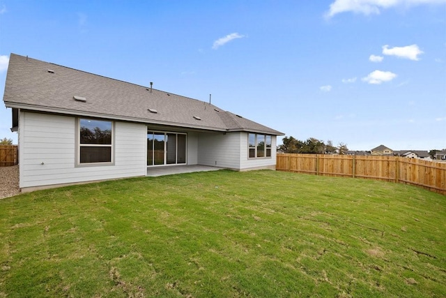 back of house with a patio area and a yard