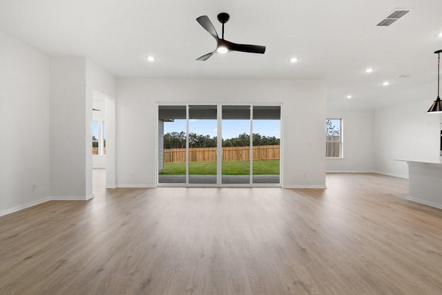 empty room featuring light hardwood / wood-style floors, ceiling fan, and a healthy amount of sunlight