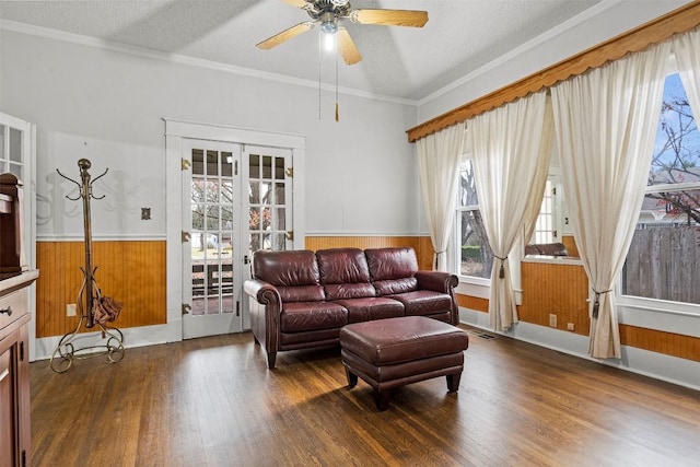 living room featuring french doors, ornamental molding, a textured ceiling, ceiling fan, and dark hardwood / wood-style floors