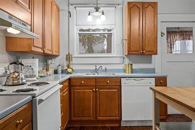 kitchen with dark hardwood / wood-style floors, white appliances, sink, and hanging light fixtures