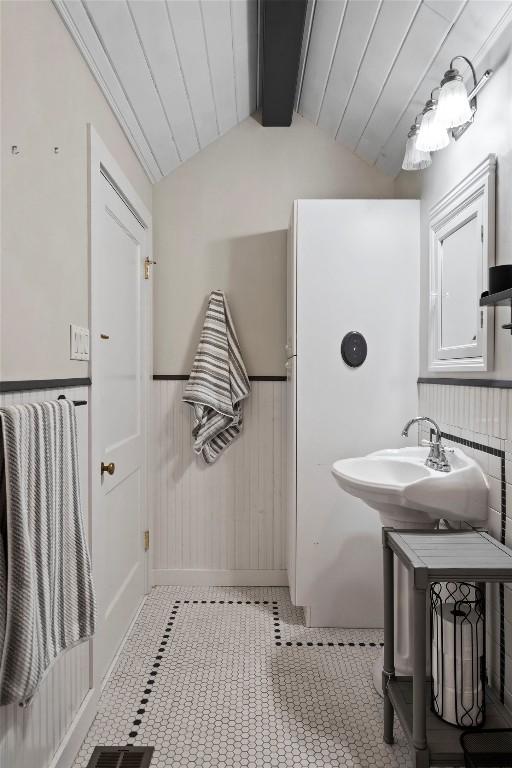 bathroom featuring vaulted ceiling with beams and sink