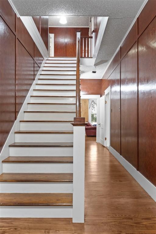 staircase with hardwood / wood-style flooring and a textured ceiling