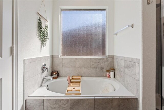 bathroom featuring a relaxing tiled tub