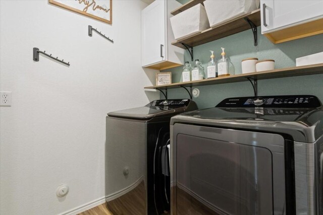 clothes washing area featuring cabinets, wood-type flooring, and independent washer and dryer