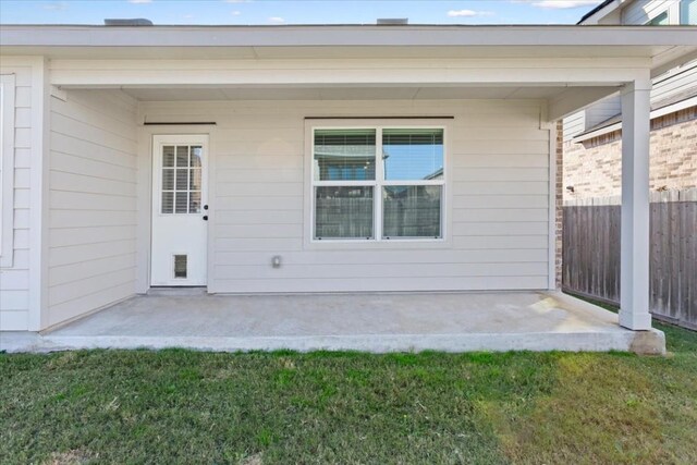 view of exterior entry with a patio