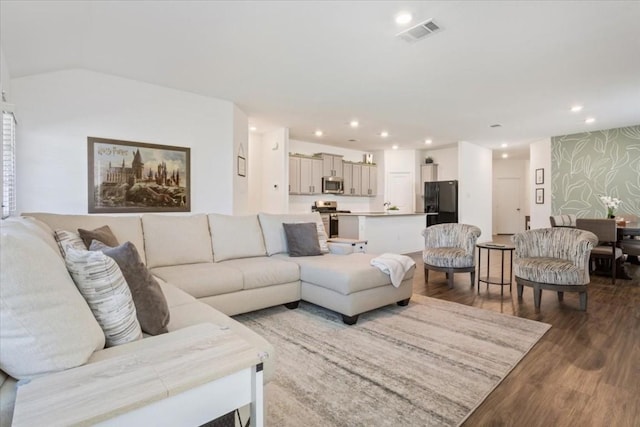 living room with wallpapered walls, wood finished floors, visible vents, and recessed lighting