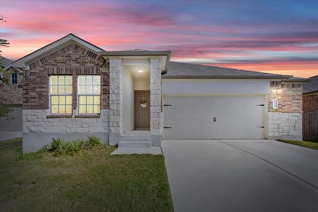 view of front of property with a garage and a yard