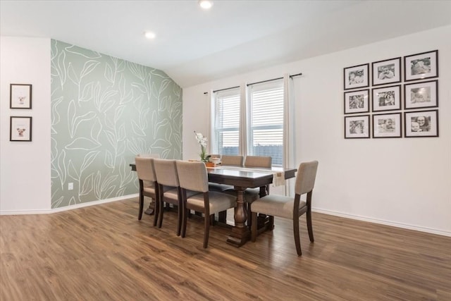 dining area featuring dark hardwood / wood-style floors and vaulted ceiling