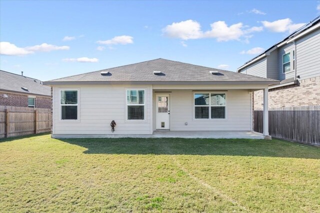 back of house with a yard and a patio