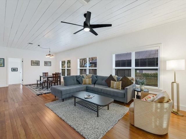 living room with wood-type flooring, ceiling fan with notable chandelier, and wood ceiling