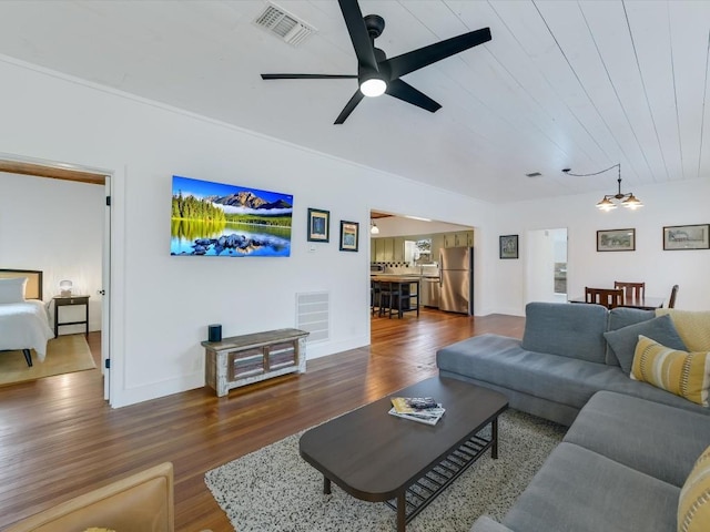 living room featuring ceiling fan with notable chandelier, dark hardwood / wood-style floors, and wooden ceiling