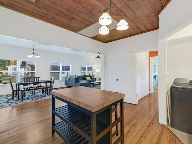 dining space with ceiling fan with notable chandelier, light wood-type flooring, washer / clothes dryer, and wooden ceiling