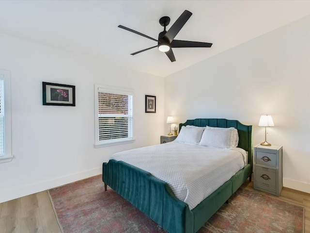 bedroom with wood finished floors, baseboards, and a ceiling fan