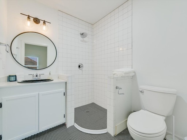 bathroom featuring tiled shower, tile patterned floors, vanity, and toilet