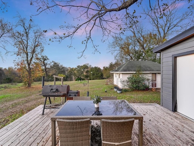 wooden deck featuring a lawn and grilling area