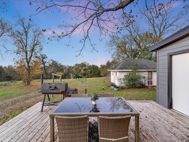 wooden terrace with an outbuilding, grilling area, a yard, and outdoor dining area